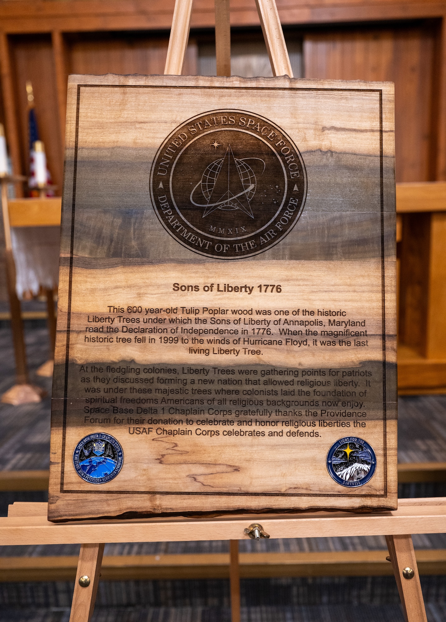 A plaque made from Liberty Tree wood on a stand