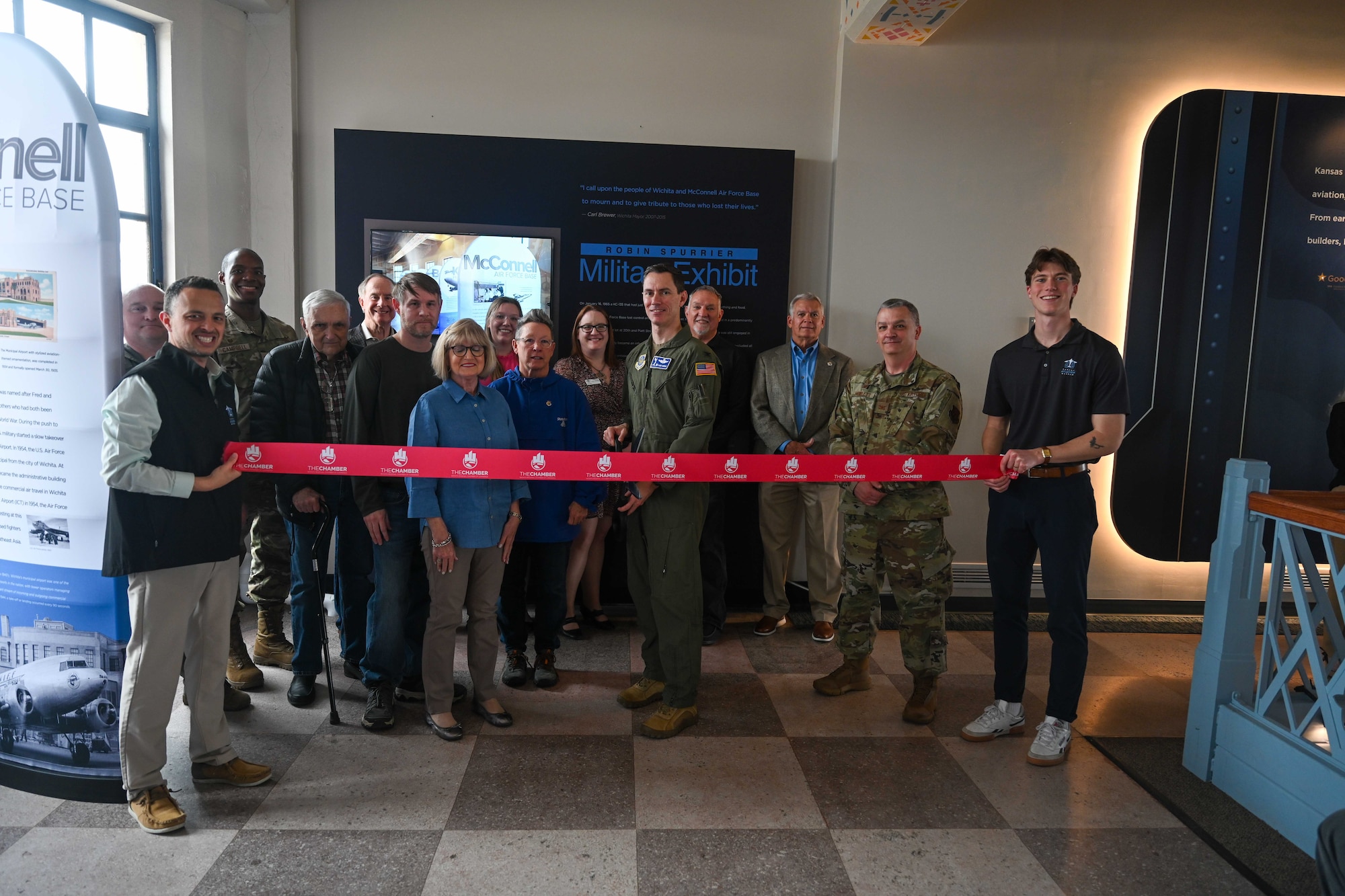 Leadership from the 22nd Air Refueling Wing cut the ribbon to the new Robbin Spurrier Exhibit April 1, 2025 in Wichita, Kansas. The Kansas Aviation Museum put on an event to cut the ribbon honoring the long-time business leader and aviation enthusiast for a display honoring his legacy as a hero in the local community. (U.S. Air Force photo by Senior Airman William Lunn)