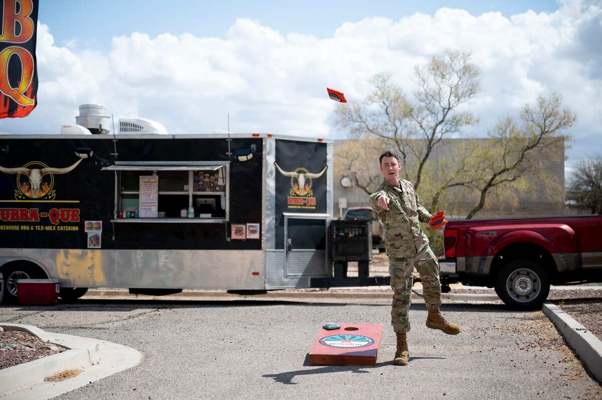 U.S. Air Force Senior Airman Devlin Bishop, 355th Wing public affairs specialist, throws a beanbag while playing cornhole during the Sexual Assault Prevention and Response office’s open house at Davis-Monthan Air Force Base, Arizona, April 4, 2025. The SAPR office provided a variety of entertainment options for visitors to engage with one another throughout the event. (U.S. Air Force photo by Airman Samantha Melecio)