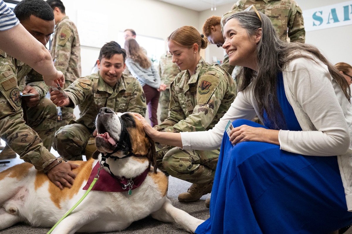 U.S. Air Force Airmen and visitors pet a therapy dog during the Sexual Assault Prevention and Response office’s annual open house at Davis-Monthan Air Force Base, Arizona, April 4, 2024. The event kicked off Sexual Assault Awareness Month and created greater awareness of SAPR’s resources and mission to the base populace. (U.S. Air Force photo by Airman Samantha Melecio)