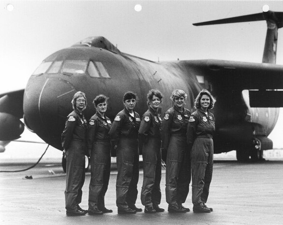 Women stand in front of plane