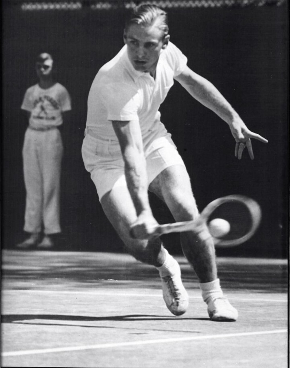 A man in athletic attire hits a tennis ball.