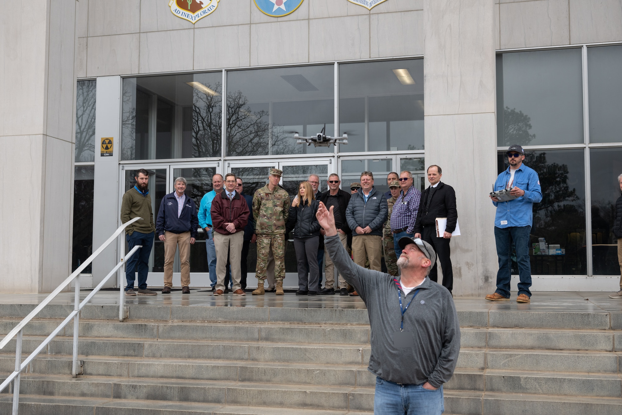 Matt Holder reaches to catch a Small Unmanned Aircraft System, also known as an sUAS or a “drone,” following a March 5, 2025, demonstration of the device at Arnold Air Force Base, Tenn. The sUAS will soon be used at Arnold to perform asset health assessments. The device is equipped with both digital and infrared imaging capabilities and will be flown around installation buildings, plant facilities and associated equipment to ensure there are no compromises to such assets and to assess the structural integrity of facilities. (U.S. Air Force photo by Keith Thornburgh) (This image has been altered by obscuring badges for security purposes)