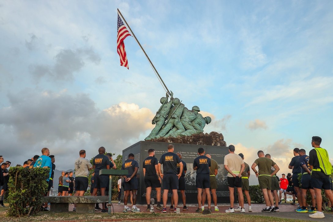 U.S. Marines and Sailors with Marine Aircraft Group 24, 1st Marine Aircraft Wing learn about the Iwo Jima Memorial during a morning physical training session in honor of the Navy Chief’s birthday at Marine Corps Base Hawaii, April 1, 2025. The rank of Chief Petty Officer was officially established on April 1, 1893, and is celebrated annually to Honor, Recognize, and Celebrate the fundamental role they play in the United States Navy. (U.S. Marine Corps photo by Lance Cpl. Chandler Evans)