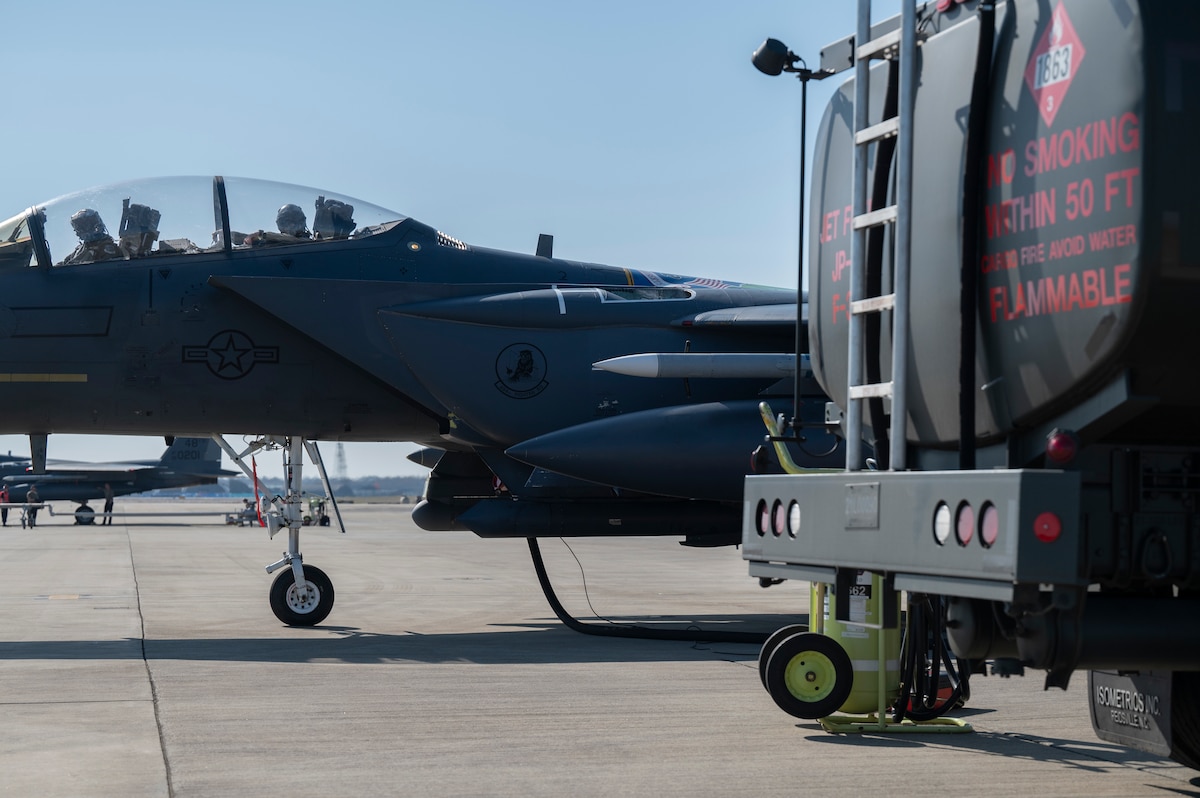 A fuel truck sits in front of an F-15E Strike Eagle.