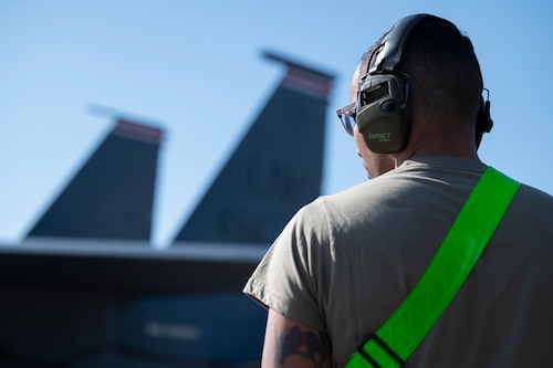 U.S. Air Force Staff Sgt. Treshaun Lambert stands by an F-15E Strike Eagle aircraft.