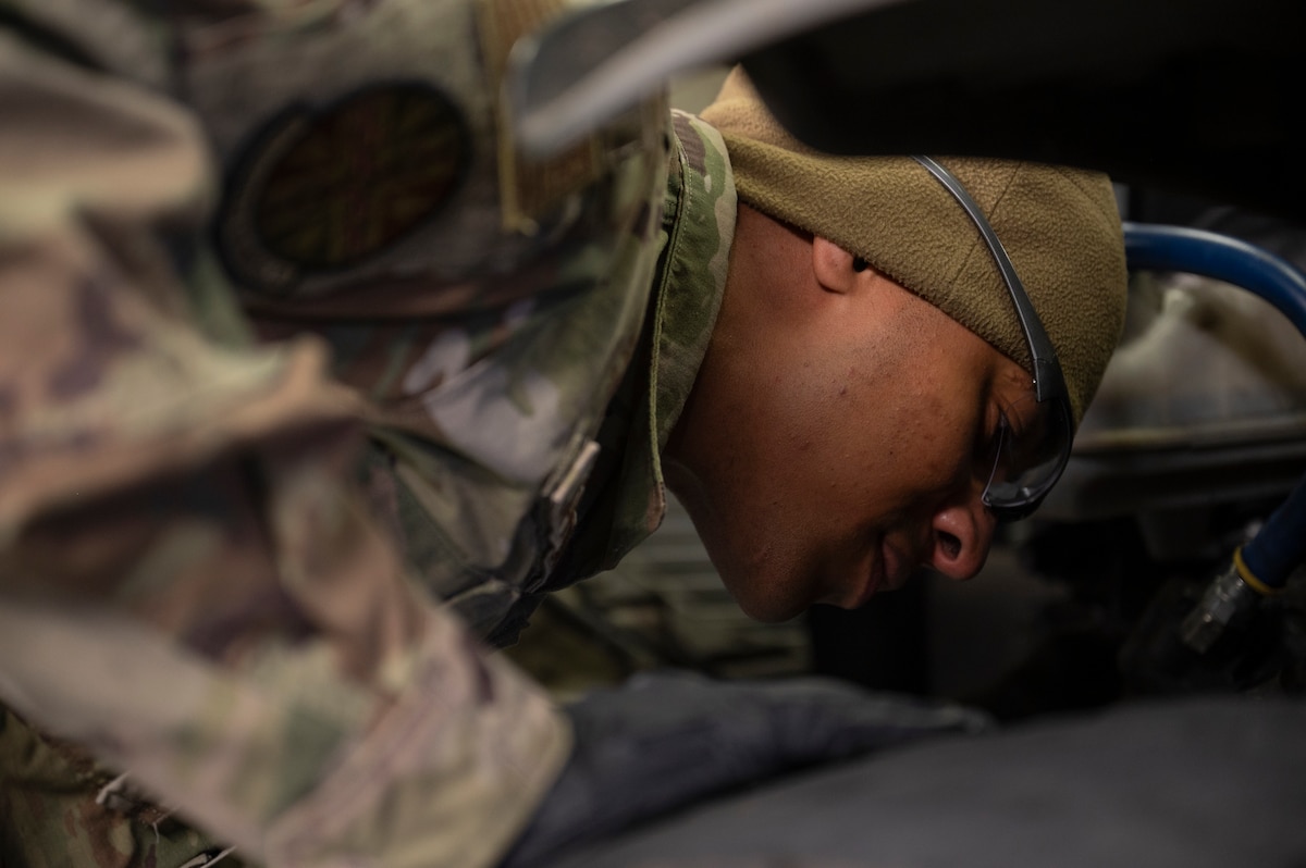Airman works on a fuel truck engine.