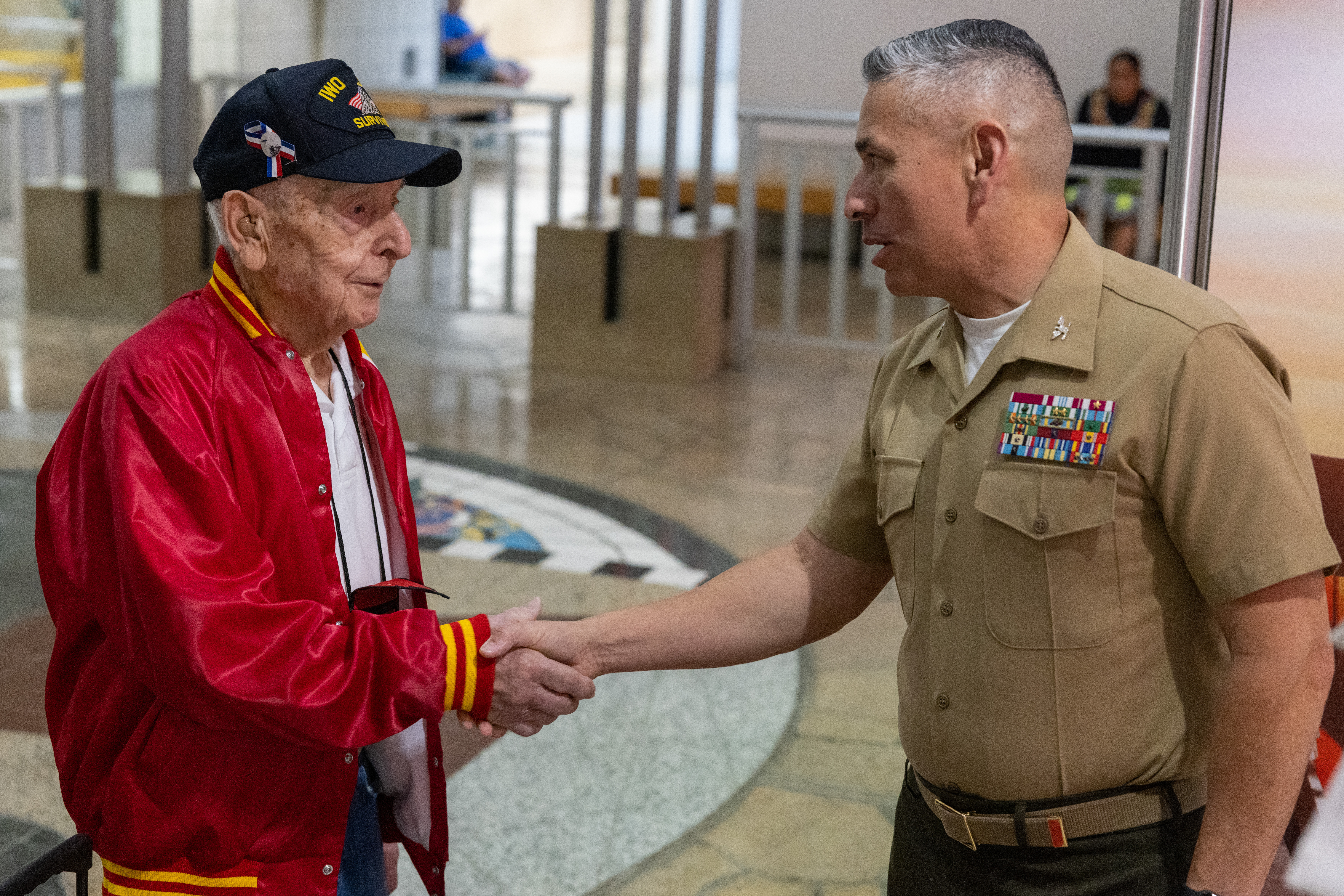 U.S. Marine Corps Col. Ernest Govea, commanding officer, Marine Corps Base Camp Blaz, greets retired Marine Corps Staff Sgt. Joseph Caminiti, a veteran of the Battle of Iwo Jima, during his tour of the pacific islands that were part of the World War II island hopping campaign, Tamuning, Guam, March 25, 2025.  Approximately 25,000 American and Japanese troops died during the battle between February 19 and March 26, 1945. (U.S. Marine Corps photo by Cpl. Ryan Little)