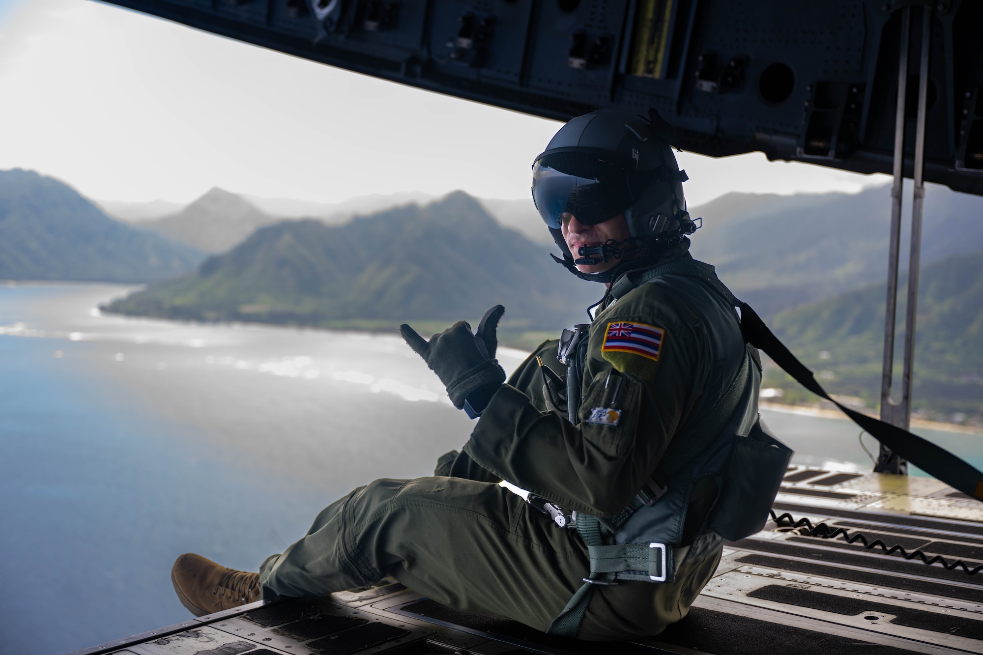 Airman rides on a C-17 ramp during flight.
