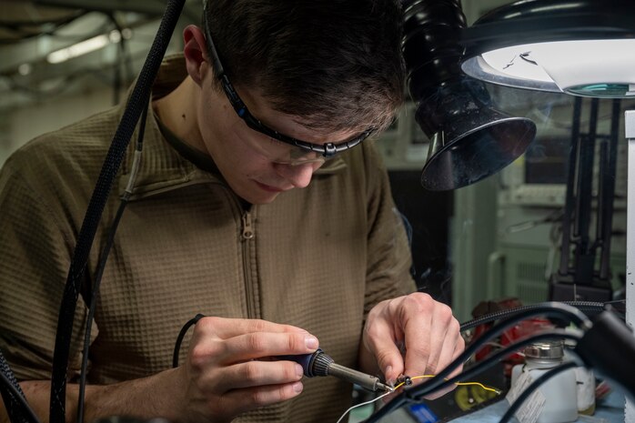 U.S. Air Force Senior Airman Gabriel Garner, 35th Maintenance Squadron avionics flight electronic warfare systems technician, solders components