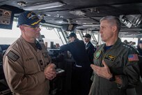 Adm. Steve Koehler, commander, U.S. Pacific Fleet, right, speaks with Capt. Douglas Grabber, commanding officer of aircraft carrier USS Nimitz (CVN 68), in the Pacific Ocean, on the bridge during a ship visit, April 4, 2025.