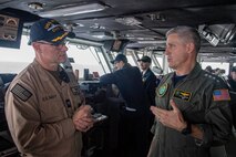 Adm. Steve Koehler, commander, U.S. Pacific Fleet, right, speaks with Capt. Douglas Grabber, commanding officer of aircraft carrier USS Nimitz (CVN 68), in the Pacific Ocean, on the bridge during a ship visit, April 4, 2025.