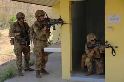 Members of the 1st Battalion, 12th Infantry Regiment, 2nd Stryker Brigade Combat Team, 4th Infantry Division, Fort Carson, Colorado, watch for simulated enemy combatants during Military Operations on Urbanized Terrain (MOUT) training with the Royal Thai Army on March 16, 2025, in Lop Buri, Thailand.