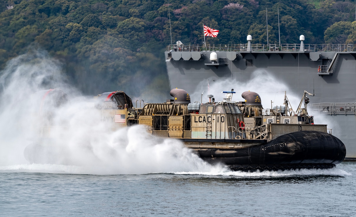 A Landing Craft Air Cushion (LCAC) assigned to Naval Beach Unit (NBU) 7 transits the Juliet Basin alongside the Japanese Maritime Self-Defense Force (JMSDF) Kongo-class guided-missile destroyer JS Kongo (DDG 173) at Commander, Fleet Activities Sasebo (CFAS) in support of the Sasebo Fleet Friendship Day open-base event April 5, 2025.