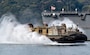 A Landing Craft Air Cushion (LCAC) assigned to Naval Beach Unit (NBU) 7 transits the Juliet Basin alongside the Japanese Maritime Self-Defense Force (JMSDF) Kongo-class guided-missile destroyer JS Kongo (DDG 173) at Commander, Fleet Activities Sasebo (CFAS) in support of the Sasebo Fleet Friendship Day open-base event April 5, 2025.