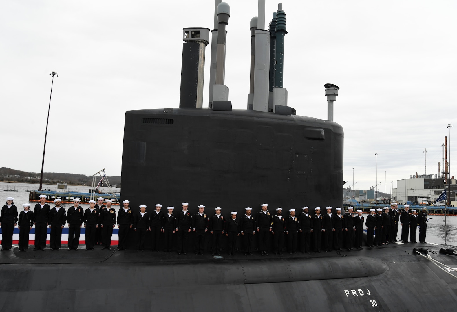 (April 5, 2025) – Sailors attached to the fast-attack submarine USS Iowa (SSN 797) man their newly commissioned submarine during a ceremony in Groton, Connecticut, April 5, 2025.