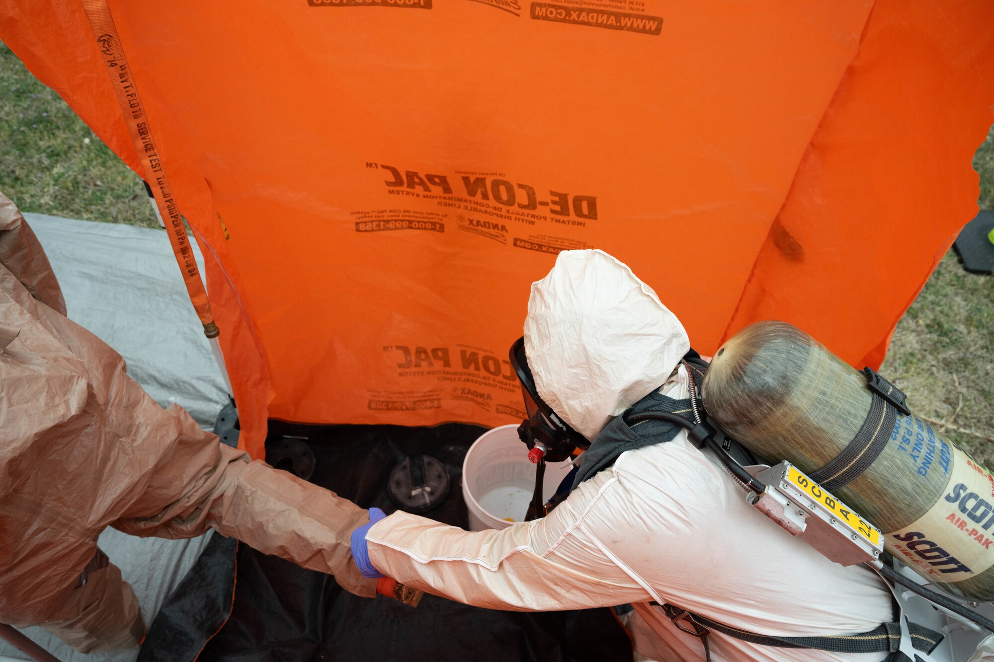 An Airman assigned to the 22nd Medical Group exits a decontamination shower after being scrubbed for any biohazard at McConnell Air Force Base, Kansas, March 28, 2025. The shower was used during a class where simulated hazardous material was identified and removed from a controlled area. (U.S. Air Force photo by Airman 1st Class Patrick O’Neill)
