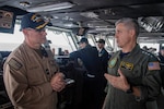 Adm. Steve Koehler, commander, U.S. Pacific Fleet, right, speaks with Capt. Douglas Grabber, commanding officer of aircraft carrier USS Nimitz (CVN 68), in the Pacific Ocean, on the bridge during a ship visit, April 4, 2025.