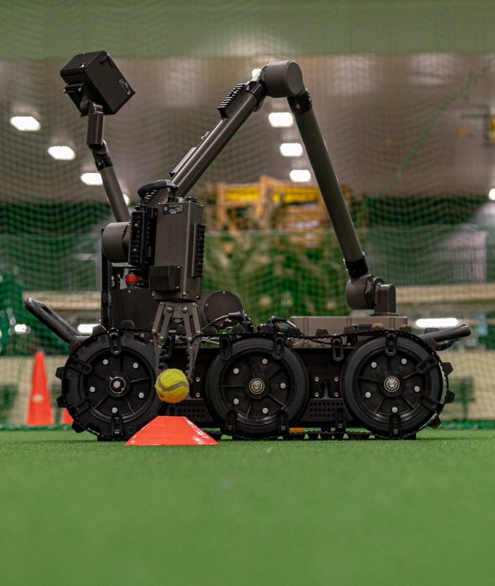 A Man Transportable Robot System places a tennis ball on a cone during Operation CODE (Children on Deployment Exercise) at Misawa Air Base, Japan, April 5, 2025. This hands-on demonstration allowed children of the 35th Fighter Wing to see how advanced technology supports safety and precision in real-world operations. (U.S. Air Force photo by Senior Airman Brittany Russell)