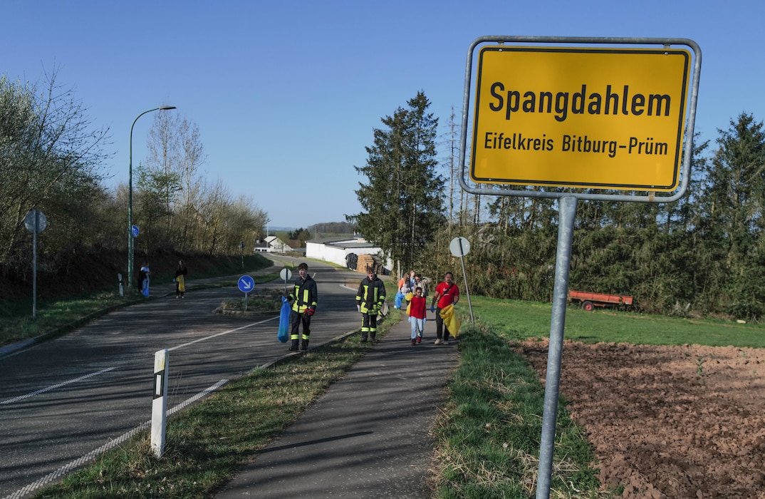 Youth firefighters from the Spangdahlem fire brigade lead a cleanup crew through the village during the Spanger Bach Cleanup in Spangdahlem, Germany, April 5, 2025. The brigade helped coordinate teams that collected trash from roads, footpaths, and along the local stream.
