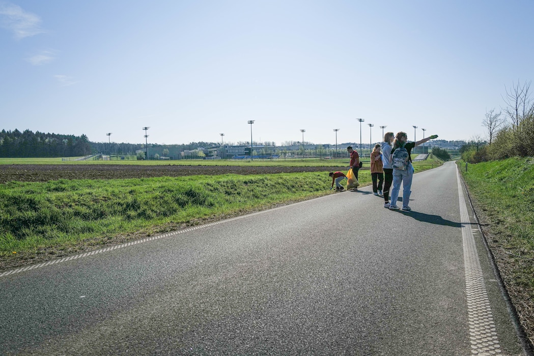 Volunteers pick up litter along the fenceline of Spangdahlem Air Base during the Spanger Bach Cleanup in Spangdahlem, Germany, April 6, 2025. The cleanup focused on reducing debris in areas that could impact local waterways.