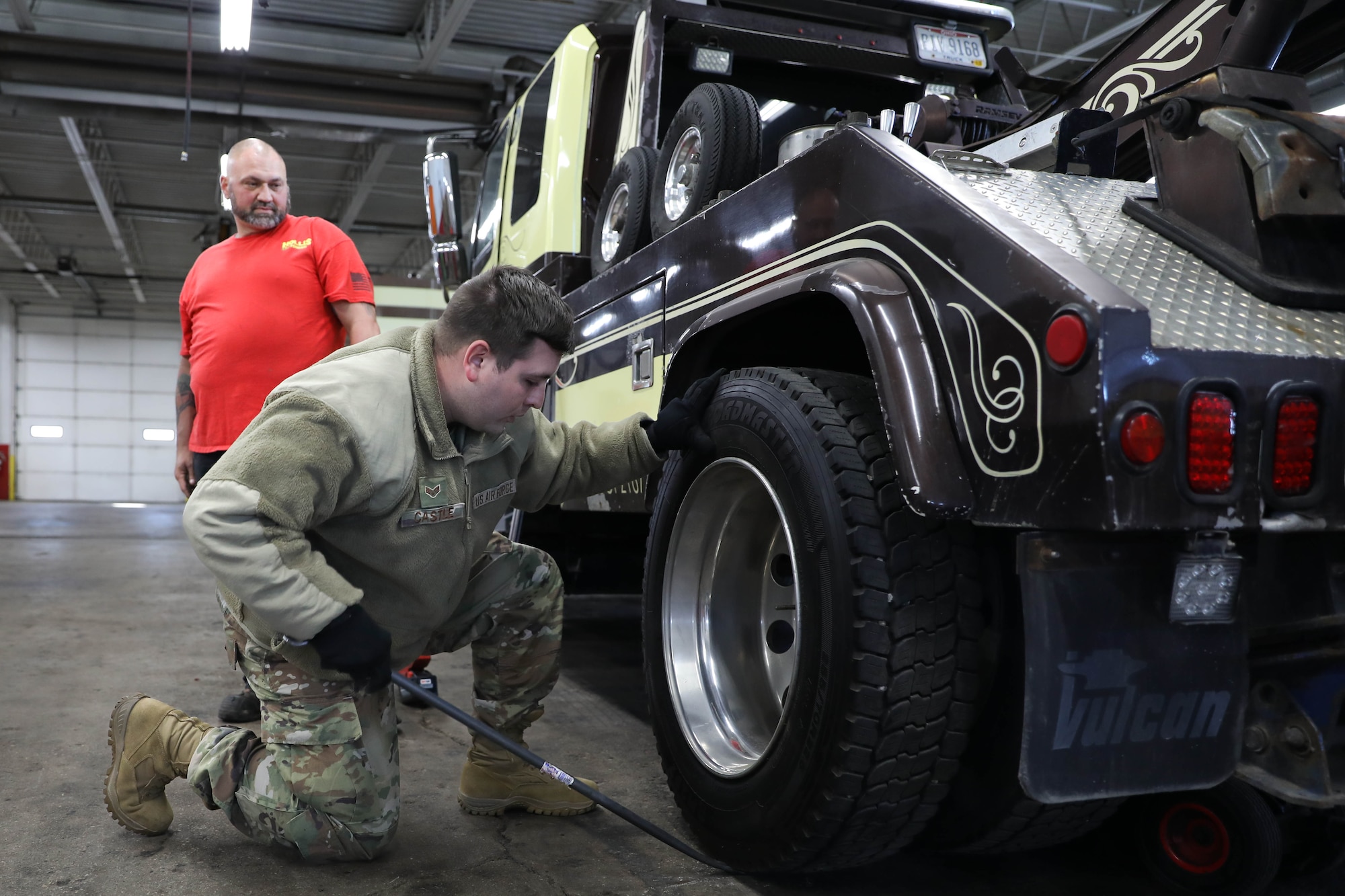 Senior Airman Andrew Castle, 445th Logistics Readiness Squadron ground transportation journeyman, replaces a tow truck wheel while Richard Dunn of Sandy’s towing observes in Dayton, Ohio, Nov. 3, 2024.