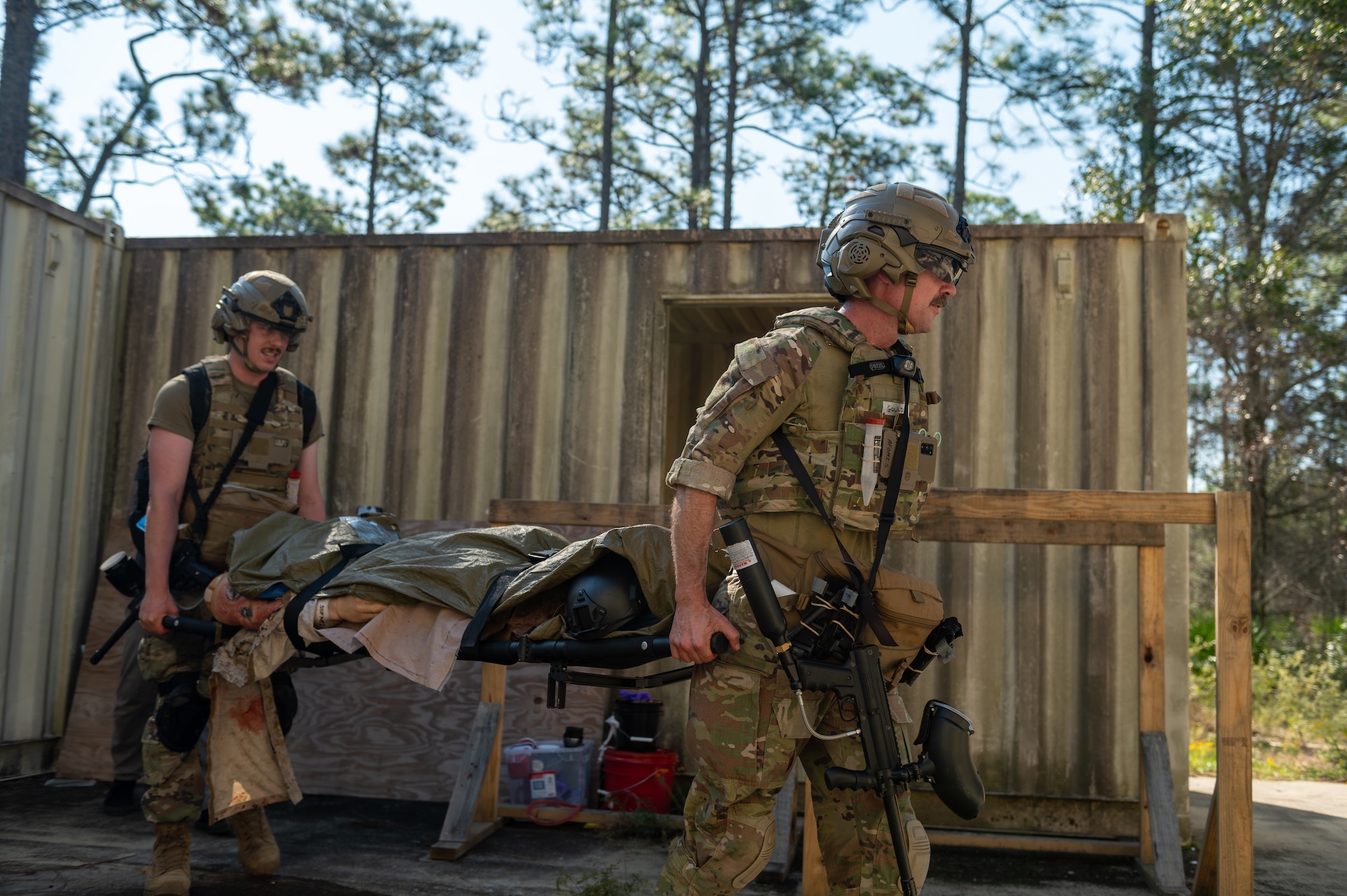 Medical Airmen transport a simulated casualty patient on a stretcher.