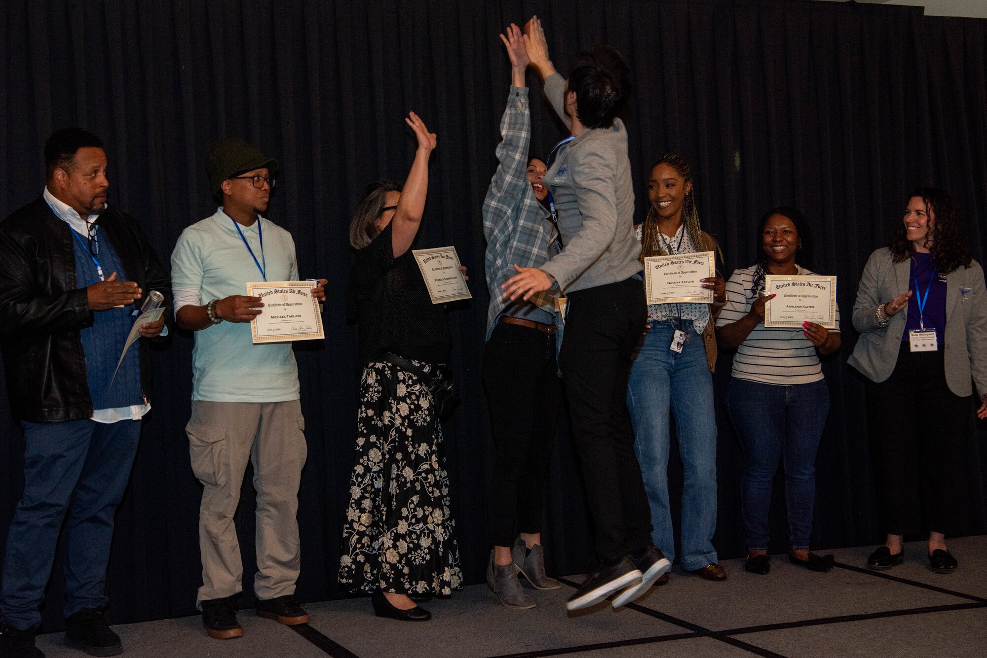 Emcee gives high fives to certificate winners.