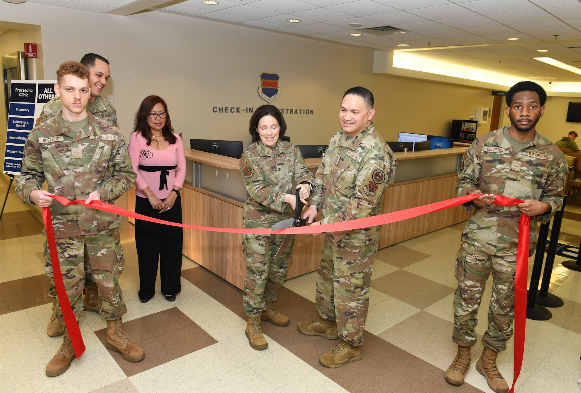 Air Force Colonel and Chief Master Sgt. cut a ribbon during the grand opening of the new central check in desk.