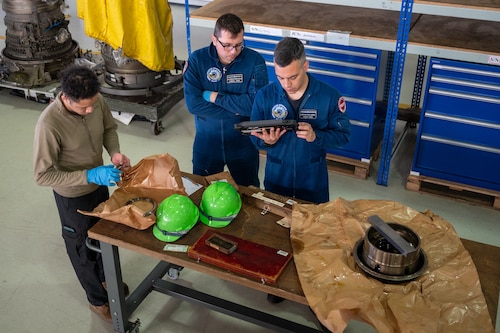 Propulsion technicians work on small pieces of an engine
