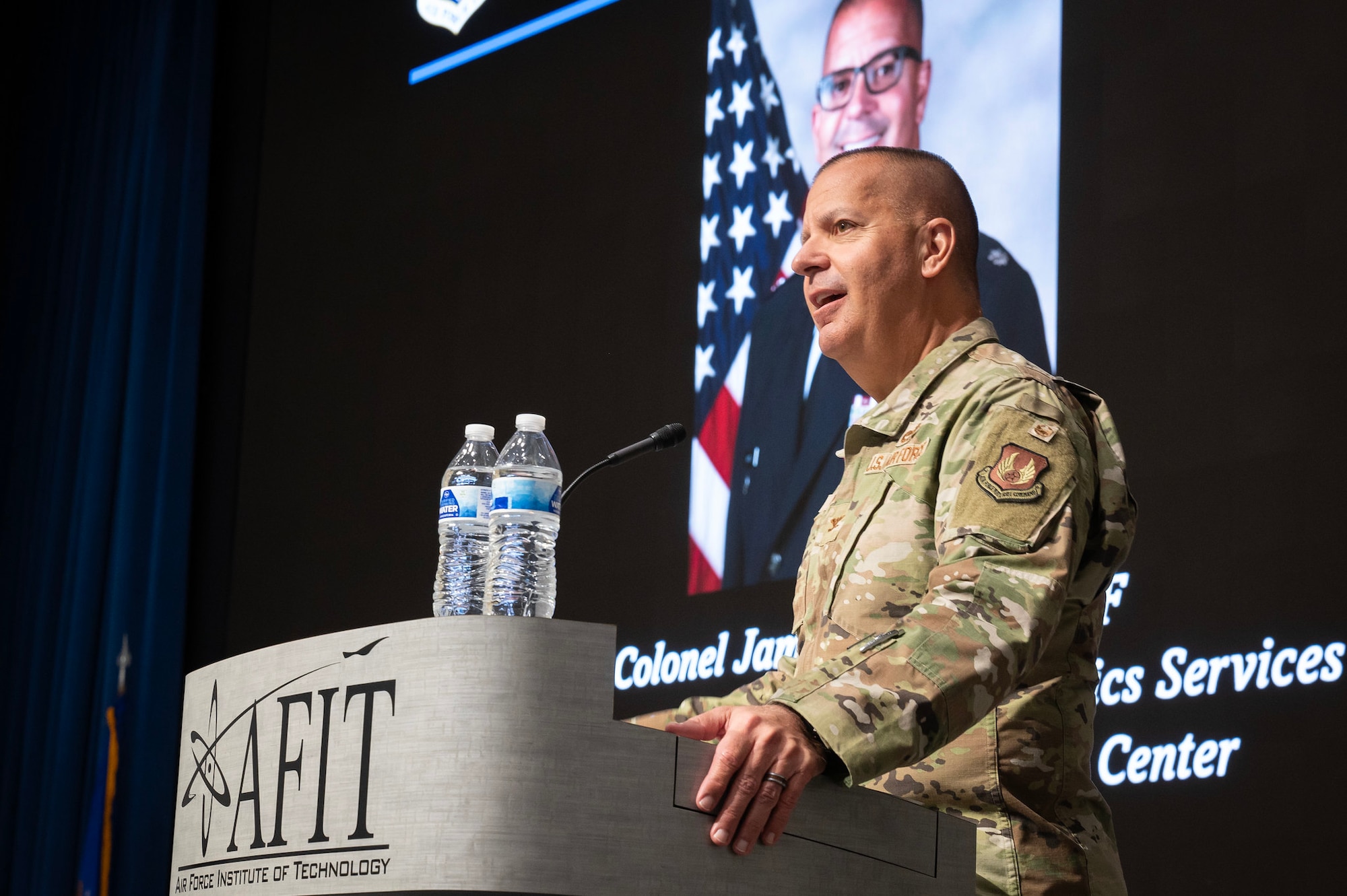 Man stands at podium in Air Force OCPs.