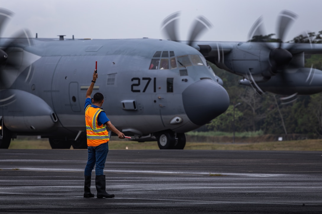 A U.S. Marine Corps C-130 Hercules aircraft with Marine Aerial Refueler Transport Squadron (VMGR) 252, 2nd Marine Aircraft Wing, is guided by a Panamanian civilian contractor at the Panamá Pacífico Airfield, Panama, April 5, 2025. 4th MAW transports personnel in support of an expanded community relationship between the U.S. and Panama. (U.S. Marine Corps photo by Lance Cpl. Van Hoang)