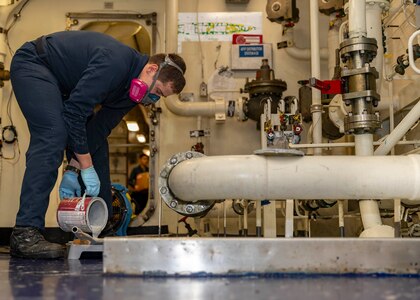 Damage Controlman Fireman Cody Lierow, assigned to engineering department aboard the world’s largest aircraft carrier, USS Gerald R. Ford (CVN 78), paints an aqueous ﬁlm-forming foam (AFFF) distribution system, April 5, 2025.