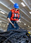 Boatswain’s Mate Seaman Apprentice Trey Avery, assigned to deck department aboard the world’s largest aircraft carrier, USS Gerald R. Ford (CVN 78), lays down a line in the hanger bay during a replenishment-at-sea (RAS), April 4, 2025.