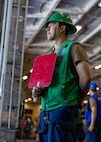Boatswain’s Mate Seaman Gerber PelicoGonzalez, assigned to deck department aboard the world’s largest aircraft carrier, USS Gerald R. Ford (CVN 78), signals to the fast combat support ship USNS Supply (T-AOE-6) in the hangar bay during a replenishment-at-sea (RAS), April 4, 2025.