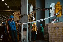 Boatswain's Mate 3rd Class Cristian Hernandez, assigned to deck department aboard the world's largest aircraft carrier, USS Gerald R. Ford (CVN 78), restrains cargo securing lines in the hangar bay during a replenishment-at-sea (RAS), April 4, 2025.