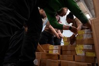 Sailors assigned to Carrier Air Wing (CVW) 8 move supply boxes in the hangar bay of the world's largest aircraft carrier, USS Gerald R. Ford (CVN 78), during a replenishment-at-sea (RAS), April 4, 2025.