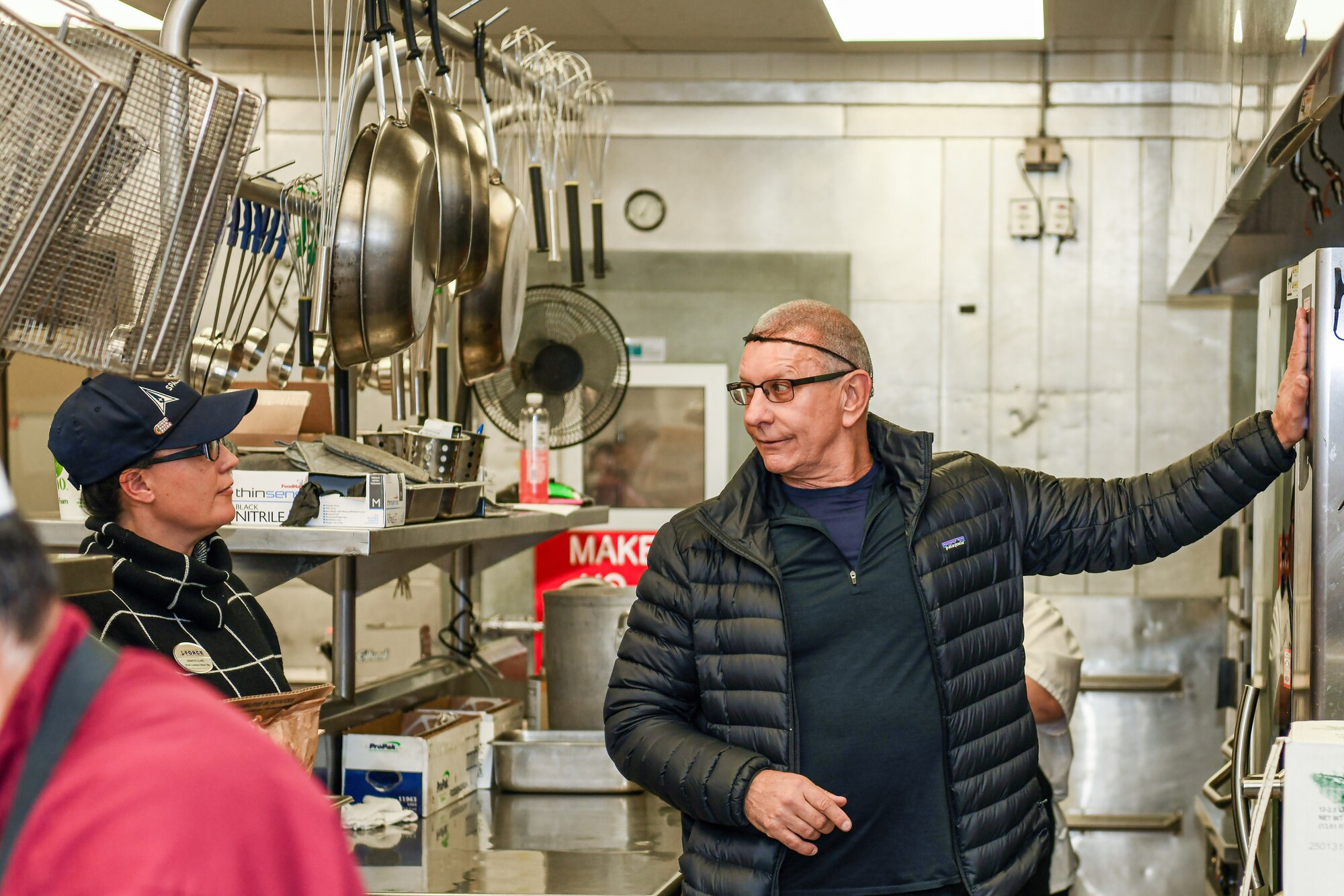 Celebrity chef Robert Irvine talks with 50th Force Support Squadron base dining facility staff members during a kitchen tour at Schriever Space Force Base, Colorado, April 3, 2025. During his visit to Schriever SFB, Irvine and the Robert Irvine Foundation toured the Child Development Center kitchen and The Dish to engage with Guardians, Airmen, and staff. (U.S. Space Force photo by Dalton Prejeant)