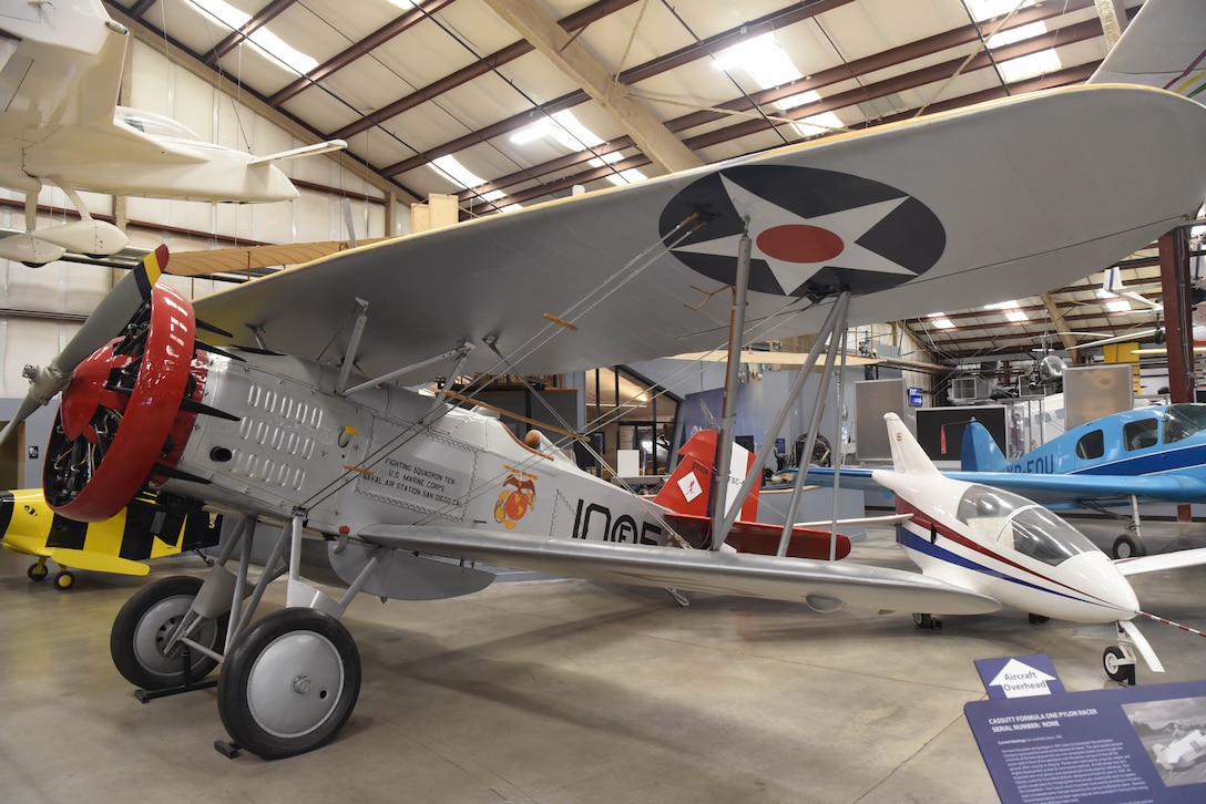 An airplane is on display in a large building with other aircraft around it.