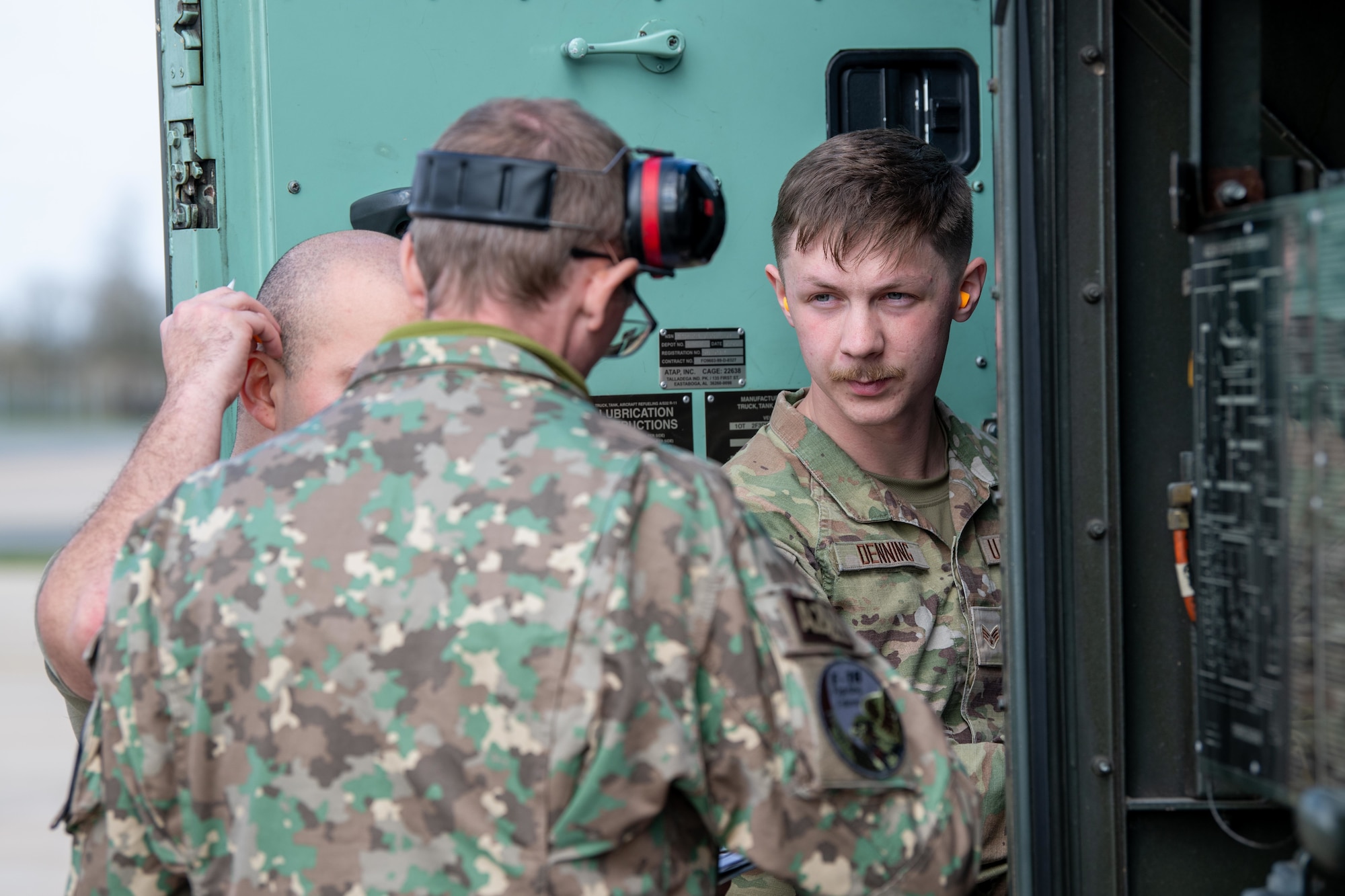 A Romanian Airman speaks with U.S. Airmen.