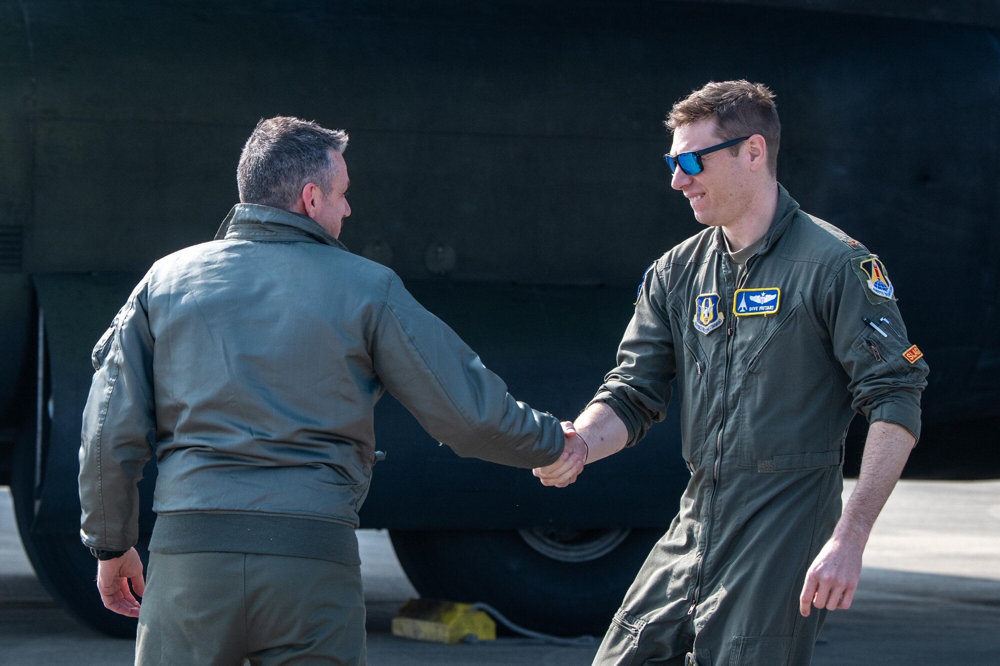 A U.S. pilot and Romanian pilot shake hands
