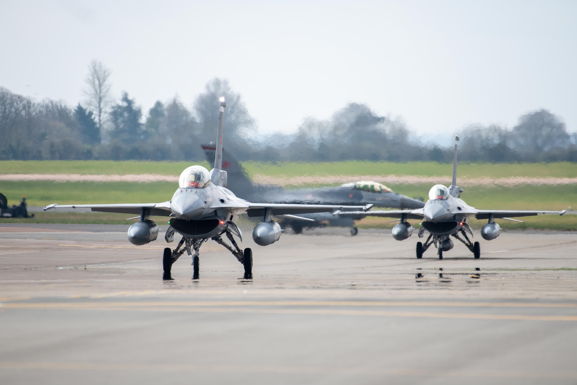 Three Turkish Air Force (THK) F-16C Fighting Falcons taxi on the flightline
