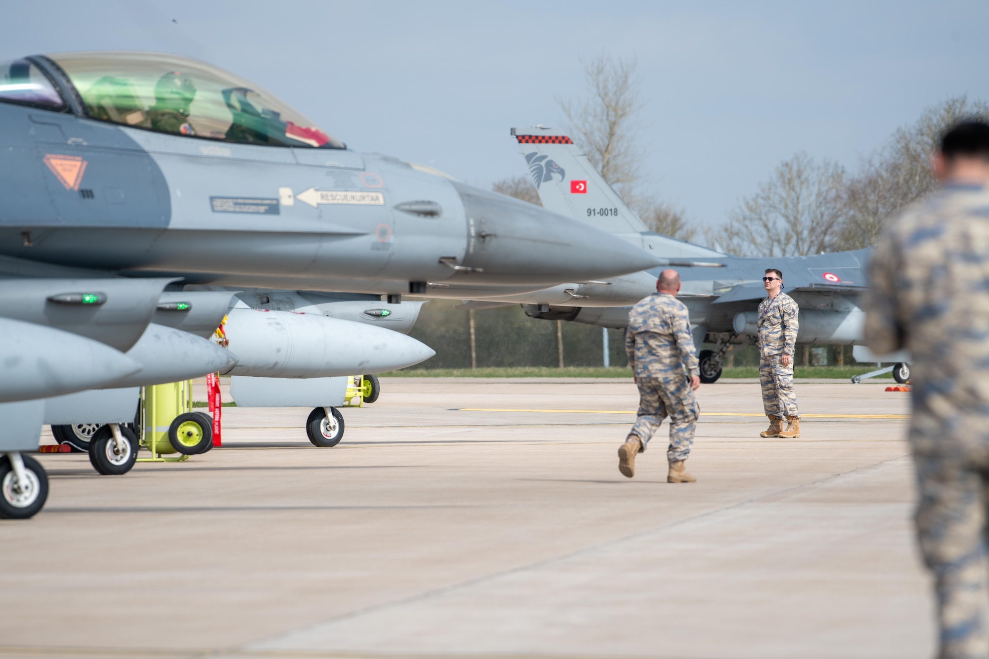 Turkish Air Force (THK) crew chiefs guide F-16C Fighting Falcons
