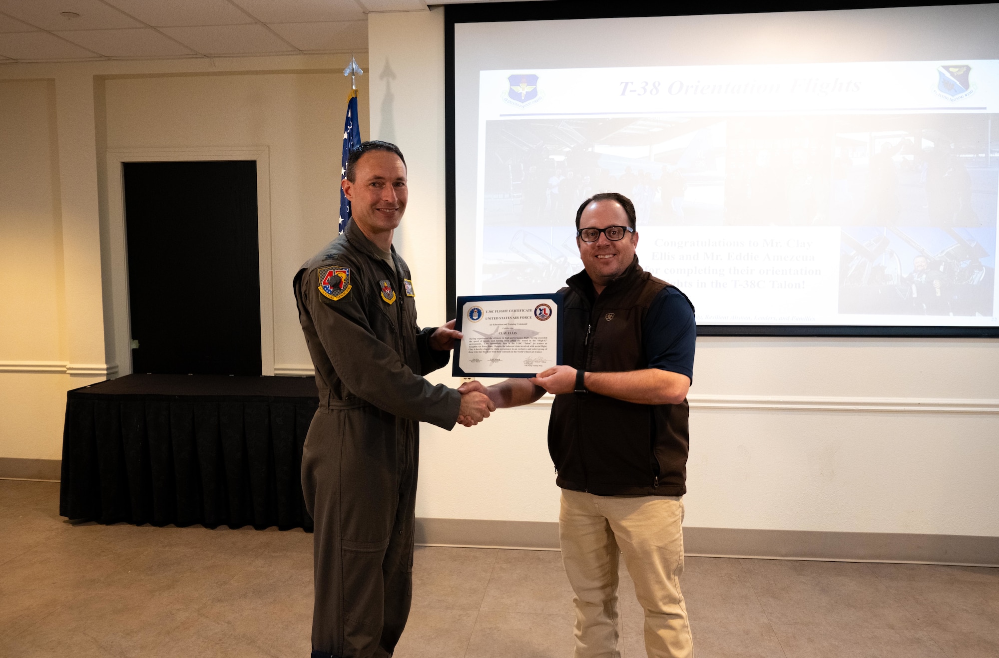 U.S. Air Force Col. Tyler Ellison, 47th Flying Training Wing, commander, awards Mr. Clay Ellis, Del Rio Military Affairs Association (MAA), vice president, with an orientation flight certificate during Laughlin’s first Wings of XLence quarterly luncheon at Laughlin Air Force Base, April 4, 2025. The Del Rio MAA coordinates efforts to strengthen/assist in possible new missions and implement measures to be taken to ensure Laughlin and Del Rio’s future relationship. (U.S. Air Force photo by Airman 1st Class Harrison Sullivan)