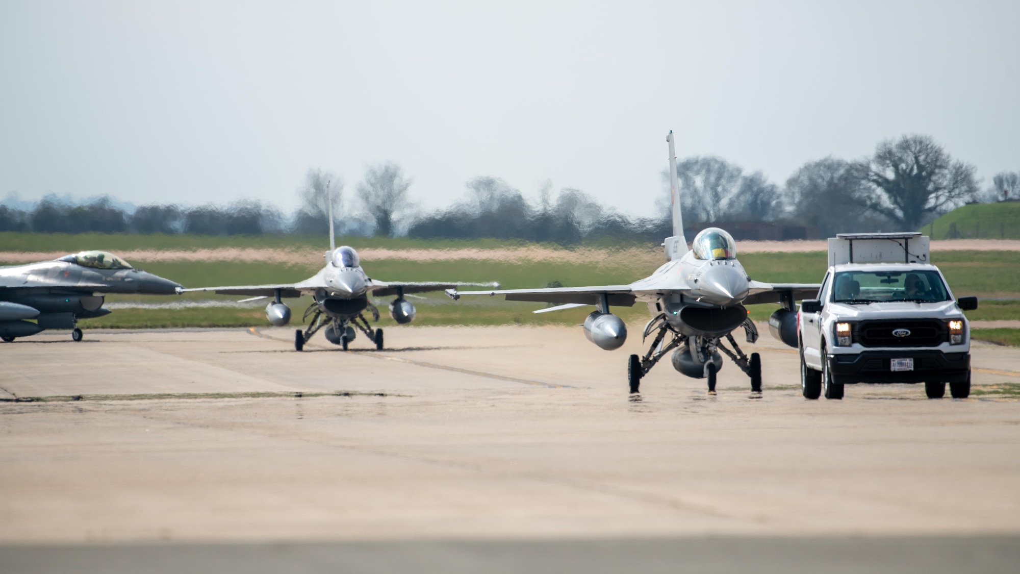 Three Romanian Air Force (RoAF) F-16AM Fighting Falcons taxi on the flightline