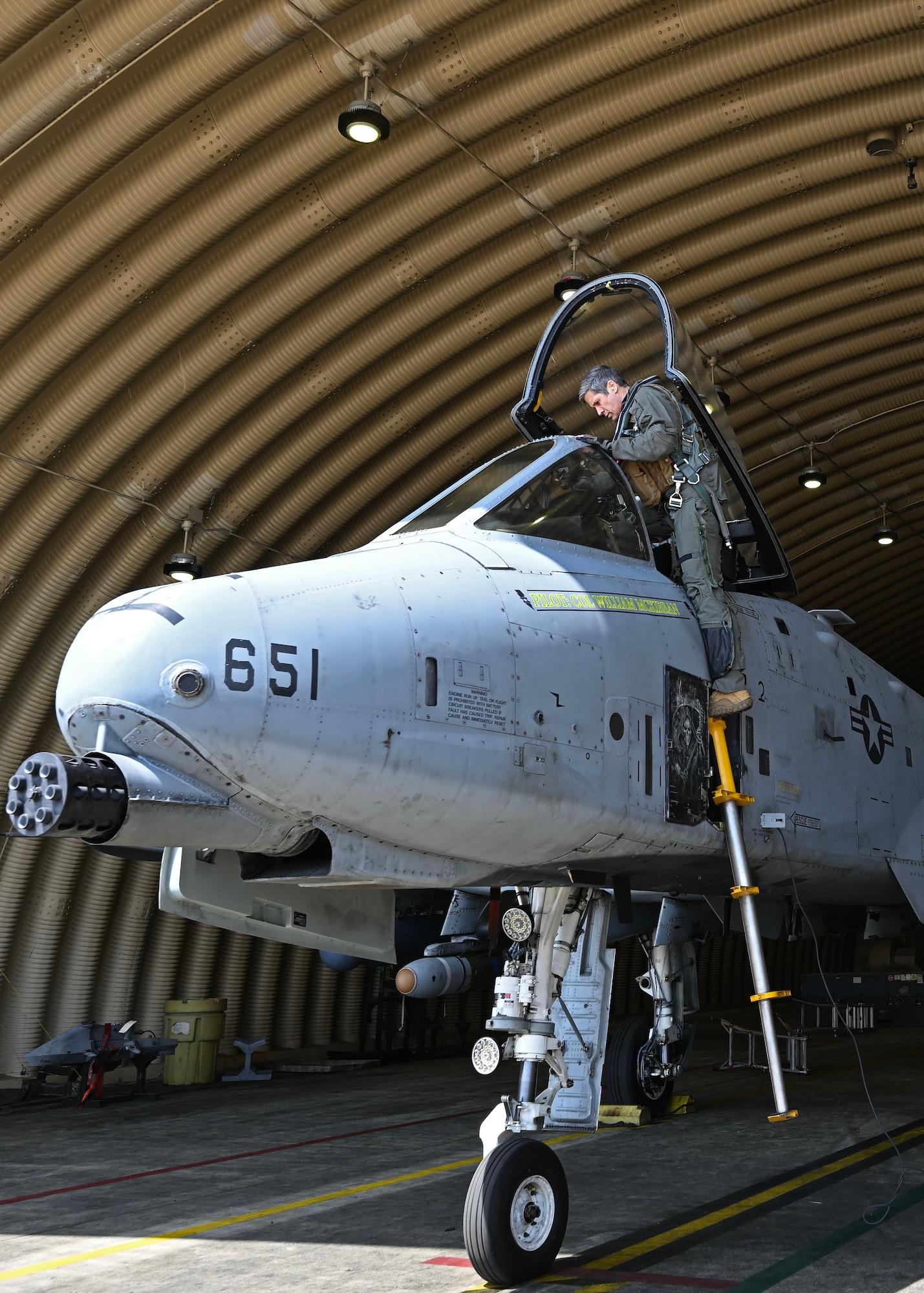 A pilot climbs into the cockpit of an A-10 Thunderbolt II