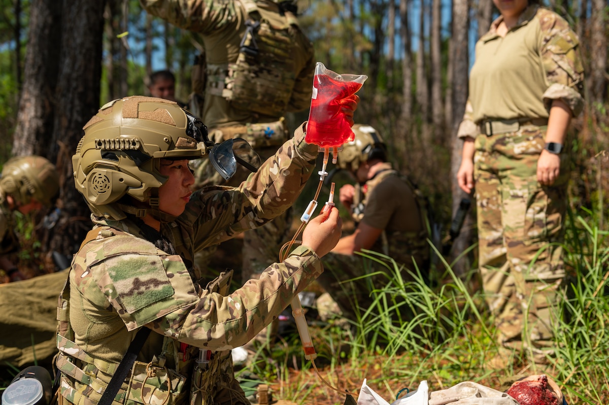 Medical Airmen holds simulated blood bag to administer.