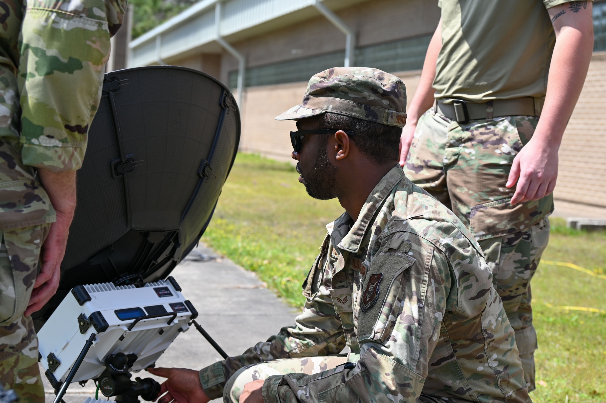 An Airmen works on a satellite dish.