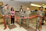 Air Force Colonel and Chief Master Sgt. cut a ribbon during the grand opening of the new central check in desk.
