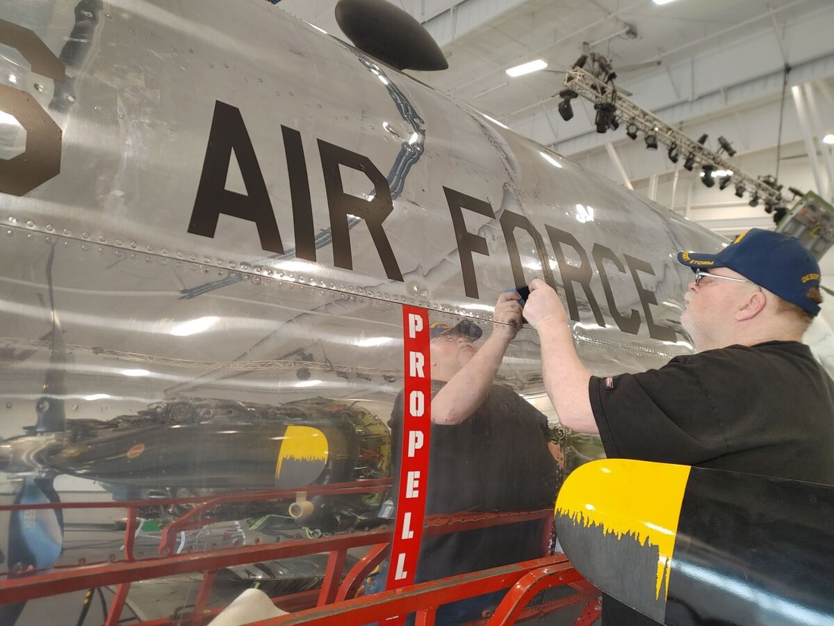 Robert Elliott, 97th Maintenance Squadron corrosion specialist, applies brand-new markings to the B-29 Superfortress ‘Doc’ in Wichita, Kansas, March 2025. Robert and his wife, Michele, were asked to join the restoration team in December 2025 to paint the original markings on Doc, as they were in 1952. (Courtesy photo)